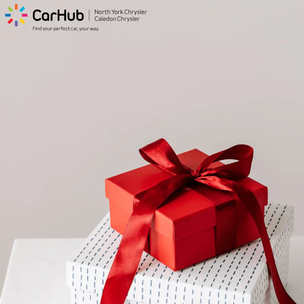 Red gift box with ribbon bow on wrapped presents CarHub dealership promotion
